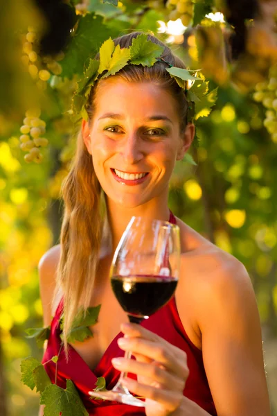 Vrouw met glas wijn in de wijngaard — Stockfoto