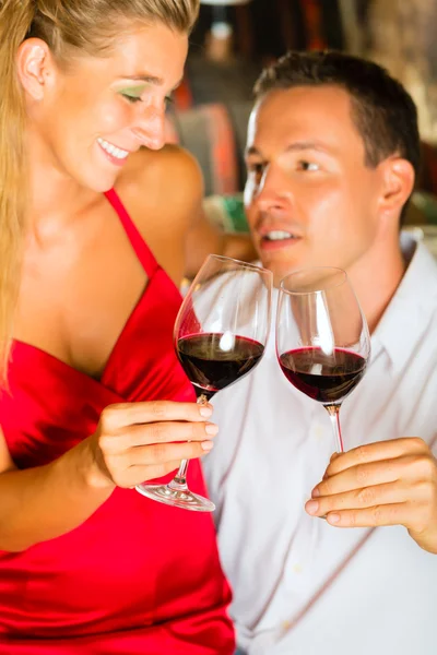 男と女のセラーでワインをマルチタスク ロイヤリティフリーのストック写真