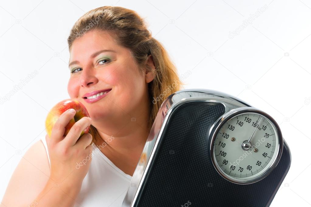 Obese woman with scale  and apple