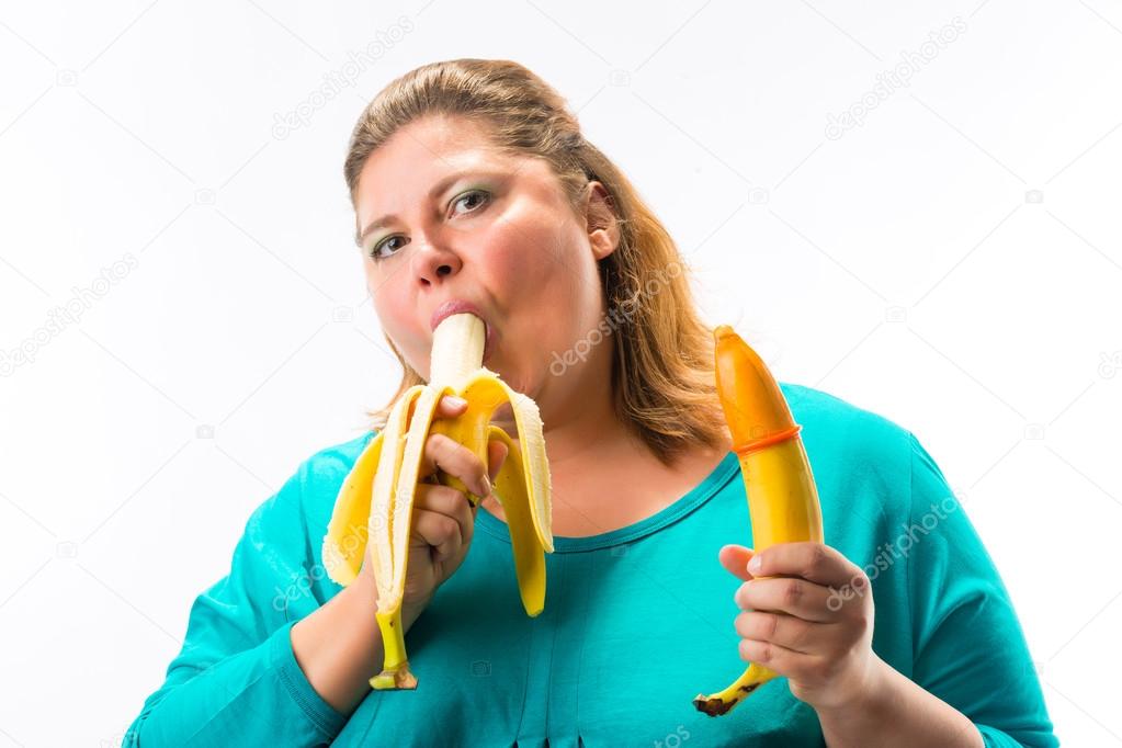 Young woman holding banana with condom 