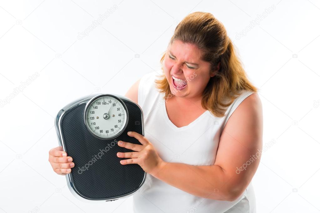 obese woman looking angry at scale