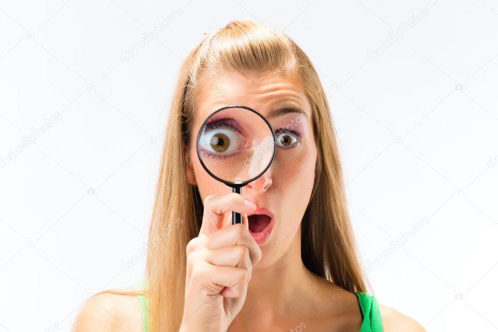 Woman looking through magnifying glass