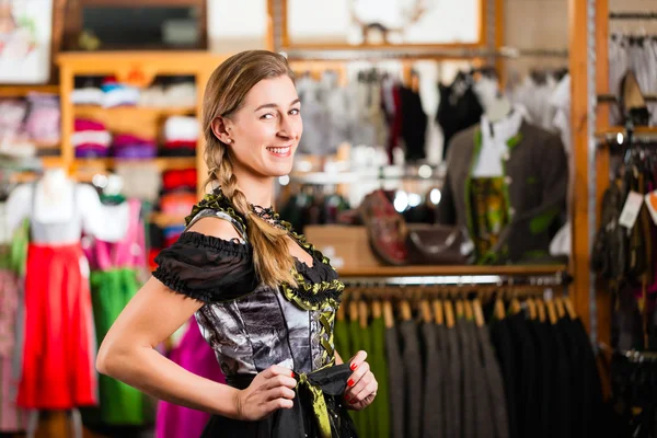 Žena se snaží Tracht nebo dirndl v obchodě. — Stock fotografie