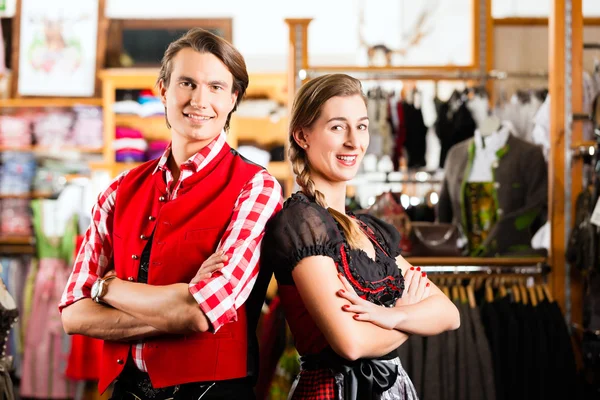 Couple is trying Dirndl or Lederhosen in a shop — Stock Photo, Image