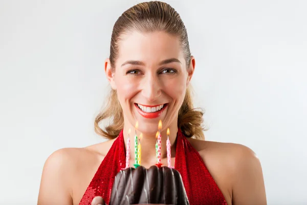 Vrouw viert verjaardag met taart en kaarsen — Stockfoto