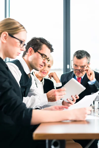 Team working with tablet at meeting in office — Stock Photo, Image