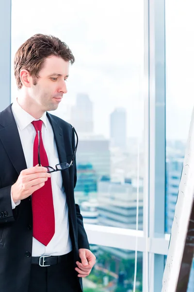 Geschäftsmann schaut im Büro auf Flipchart — Stockfoto