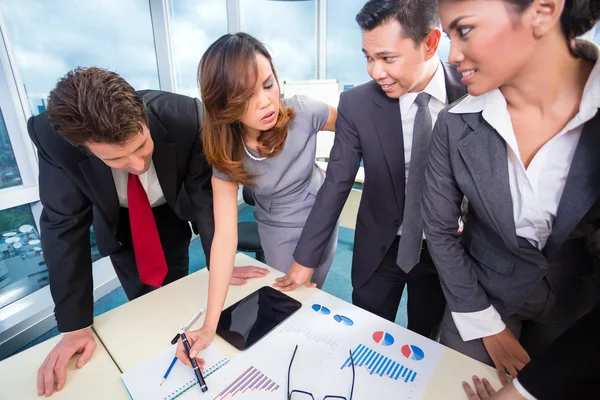 Mixed business team discussing earnings — Stock Photo, Image
