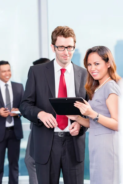 Asiatico business team di fronte alla città skyline — Foto Stock