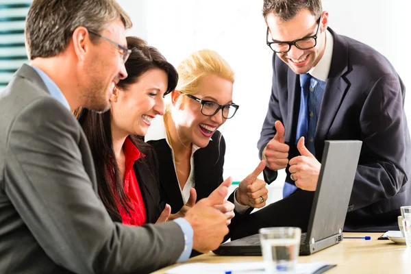 La gente di affari che guarda il computer portatile con successo — Foto Stock