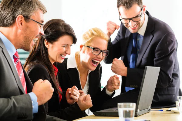 Business people looking at laptop with success — Stock Photo, Image