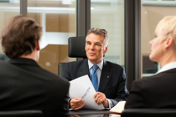 Advocaat of notaris met klanten in zijn kantoor — Stockfoto