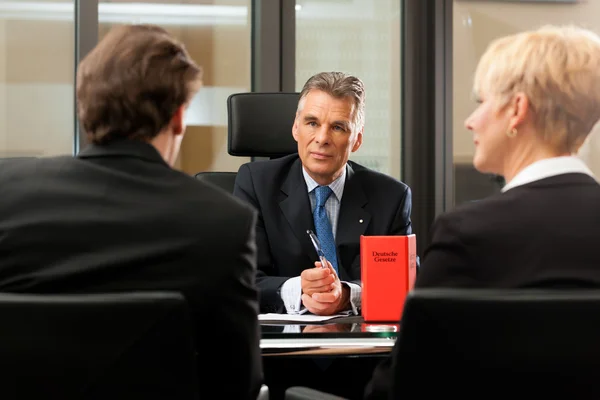 Advocaat of notaris met klanten in zijn kantoor — Stockfoto