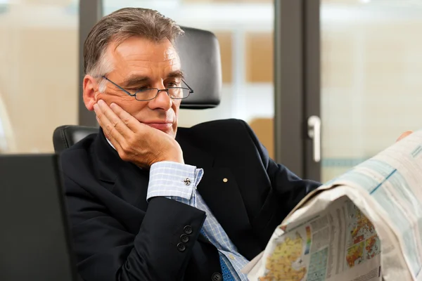 Chefe em seu escritório lendo jornal — Fotografia de Stock