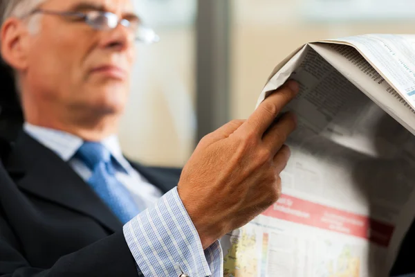 Boss in his office reading newspaper — Stock Photo, Image