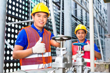 Asya teknisyen veya mühendis kapak üzerinde çalışıyor 