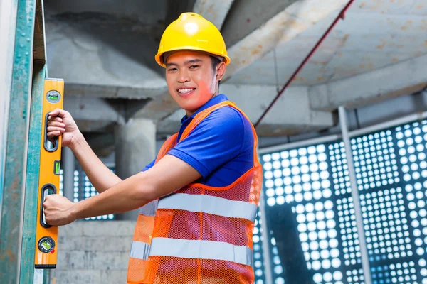 Bauunternehmer oder Arbeiter, der Mauer kontrolliert — Stockfoto