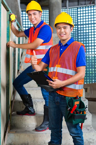 Trabalhador asiático controlando edifício — Fotografia de Stock
