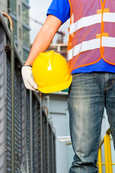 Работник на строительной площадке со шлемом — стоковое фото