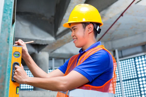 Bauunternehmer oder Arbeiter, der Mauer kontrolliert — Stockfoto