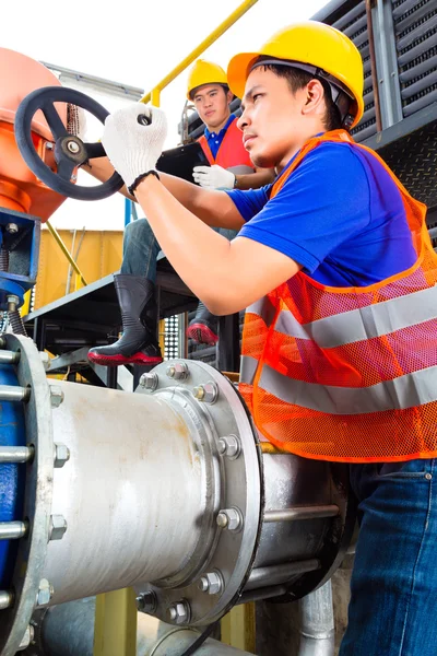Técnicos trabalhando na válvula em fábrica ou utilidade — Fotografia de Stock