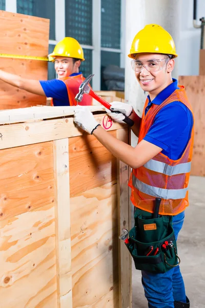 Construtor serrar uma tábua de madeira do edifício — Fotografia de Stock