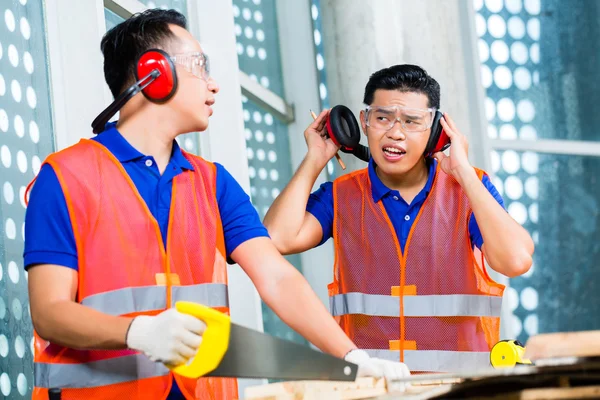 Builder sawing a wood board of building — Stock Photo, Image