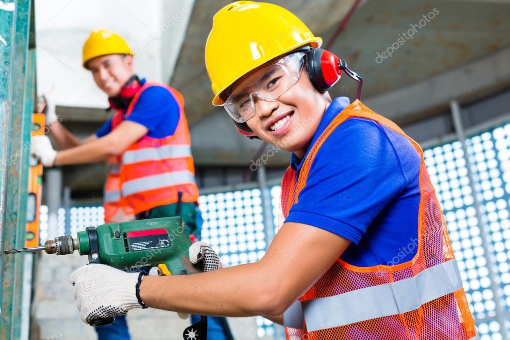 Builder sawing a wood board of building