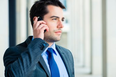 Kendine güvenen işadamı telefon kullanarak açık