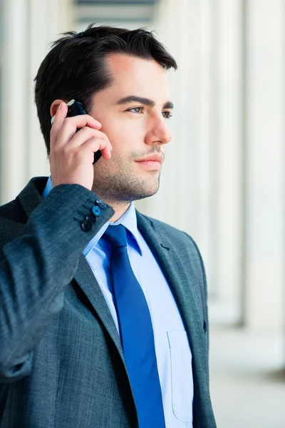 Säker affärsman utomhus med telefonen — Stockfoto