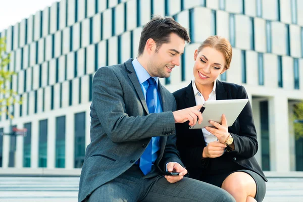 Zakenmensen werken buiten met tablet pc — Stockfoto