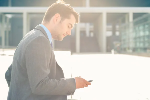 Confident businessman outdoor using phone — Stock Photo, Image