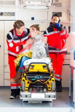 Ambulance helping injured woman clipart