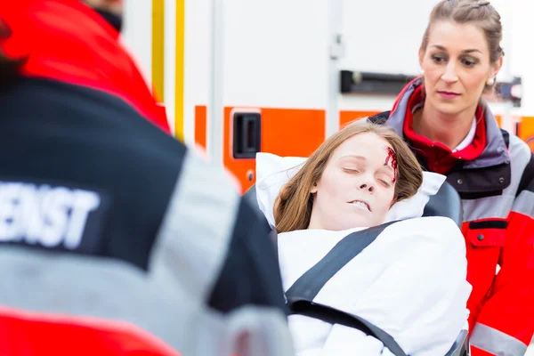 Ambulance aidant femme blessée sur civière — Photo