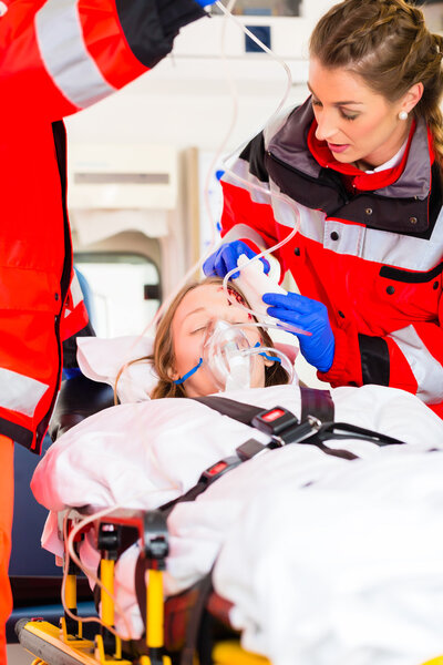 Ambulance helping injured woman on stretcher