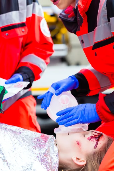 Médico de ambulância que dá oxigénio à vítima feminina — Fotografia de Stock