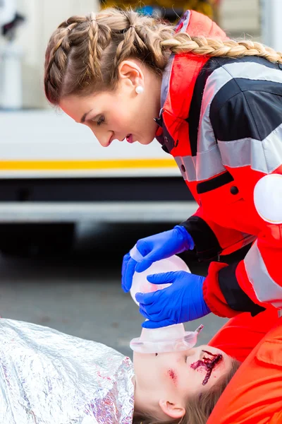Médico de ambulância que dá oxigénio à vítima feminina — Fotografia de Stock