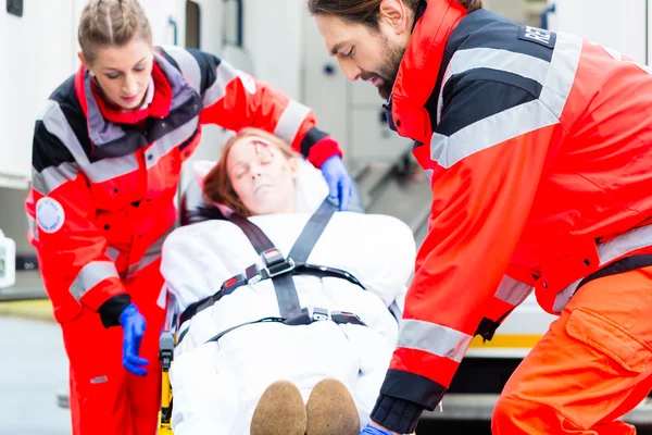 Ambulans att hjälpa skadade kvinnan på bår — Stockfoto