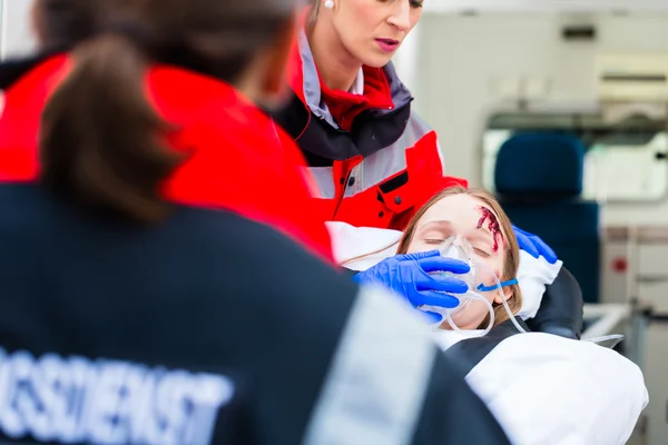 Ambulance aidant femme blessée sur civière — Photo