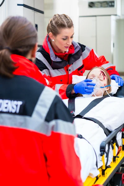 Ambulance aidant femme blessée sur civière — Photo