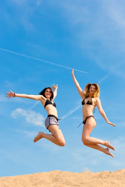 Dos mujeres felices saltando alto con diversión — Foto de Stock