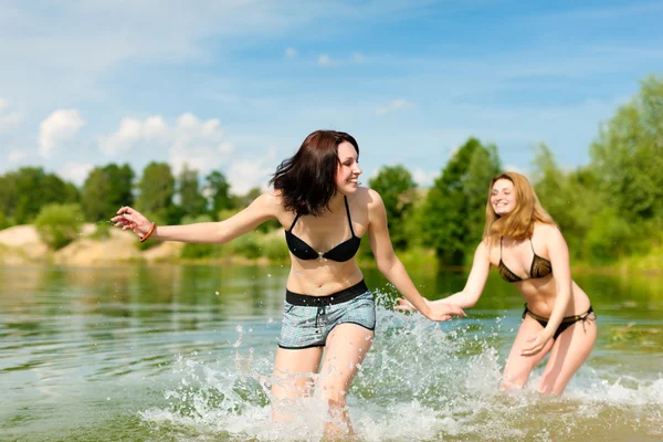 Duas mulheres felizes se divertindo no lago — Fotografia de Stock