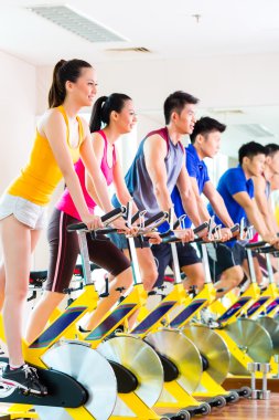 insanlar Bisiklet eğitim fitness salonunda iplik içinde