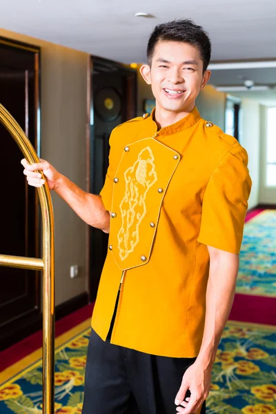 Boy or porter bringing suitcase to hotel room — Stock Photo, Image