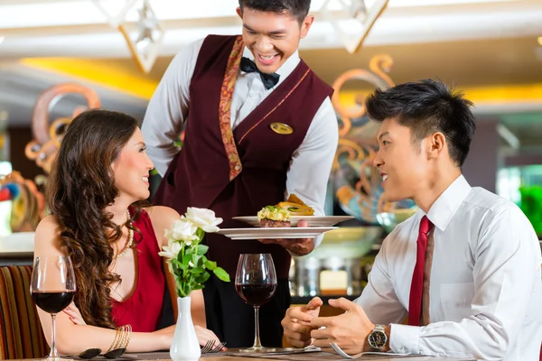 Официант, обслуживающий ужин в элегантном ресторане — стоковое фото