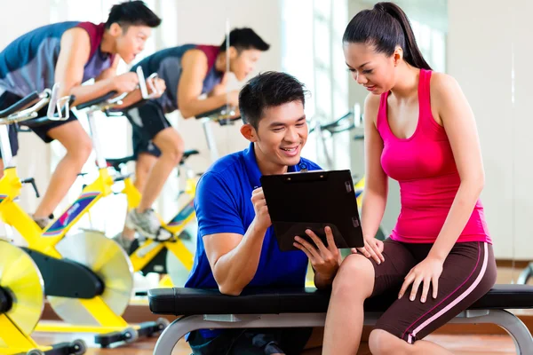 Personal trainer com mulher em fitness gym — Fotografia de Stock