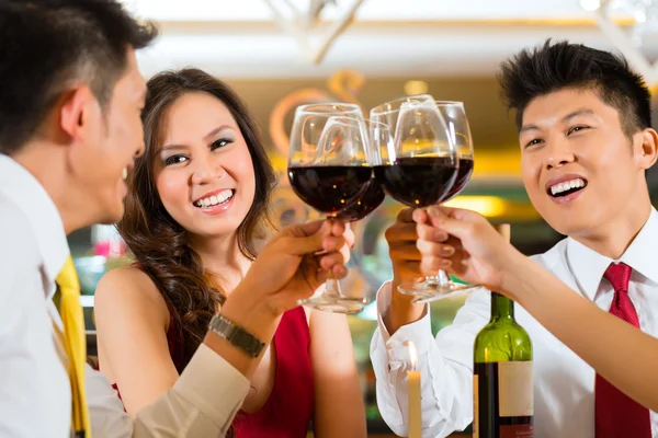 Parejas chinas brindando con vino en restaurante — Foto de Stock