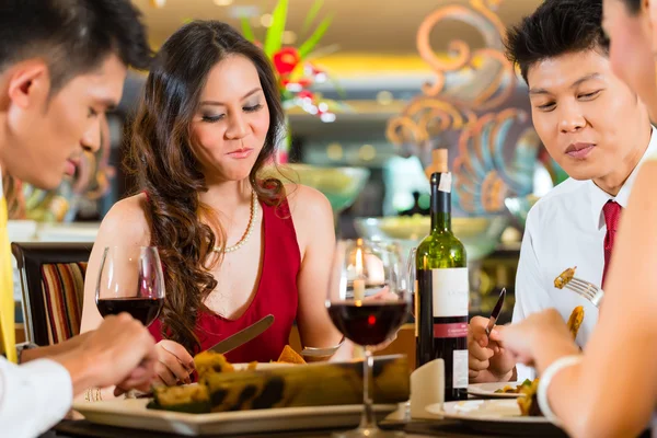 Parejas chinas brindando con vino en restaurante — Foto de Stock