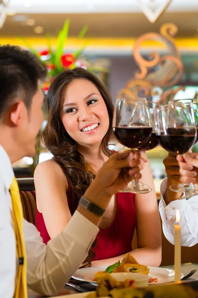 Chinese couples toasting with wine in restaurant — стокове фото