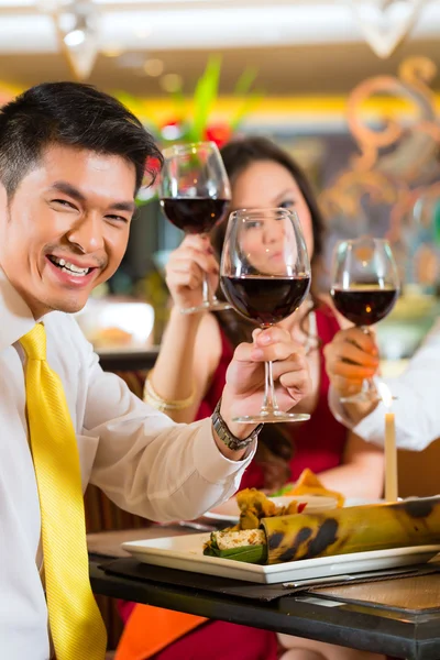 Chinese couples toasting with wine in restaurant — стокове фото